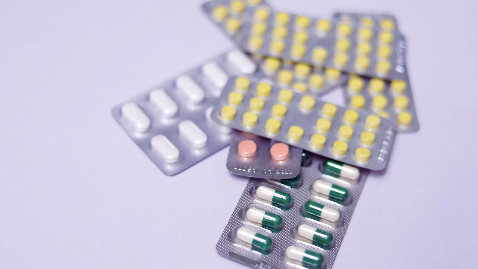 Meerdere doordrukstrips met tabletten en capsules naast elkaar.