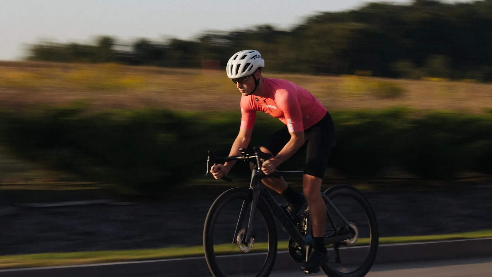 Man fietst op een racefiets over een landweg.