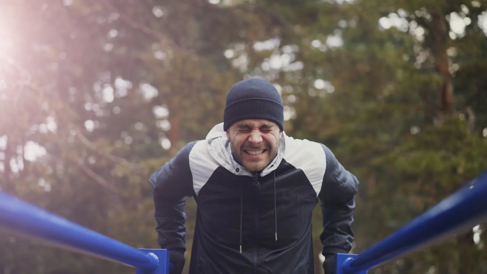 Man traint buiten op parallelle stangen in de winter.